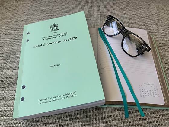 A book of legislation next to an open diary and a pair of glasses